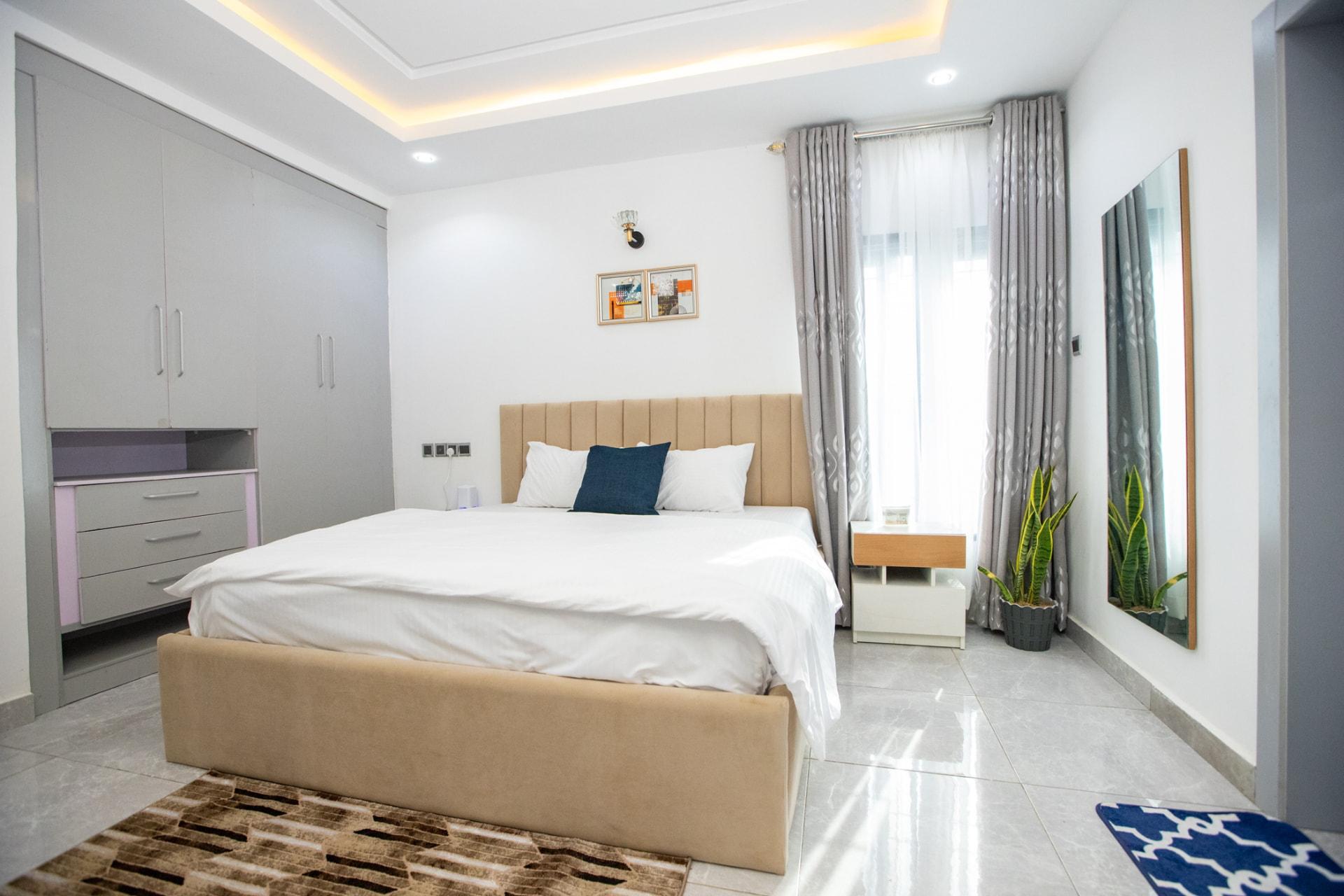 Bright bedroom with king bed, mirror and dressing area at The Graces — Dawn