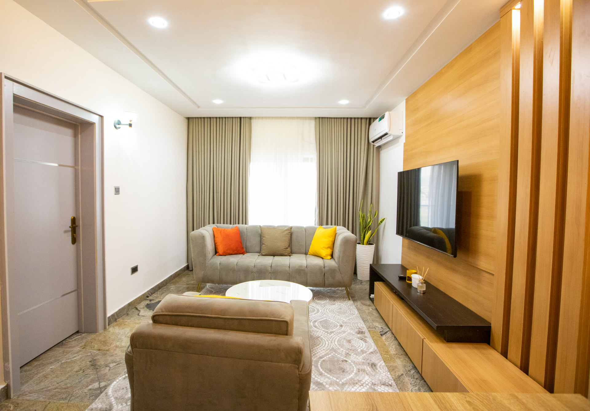 Living room with sofa, smart television and dining area at The Graces — Dawn